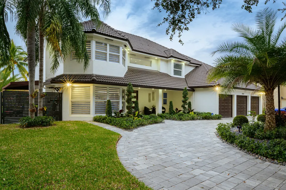 Two-story home with a tiled roof, paved driveway, and landscaped front yard from Green Home Remodeling's gallery